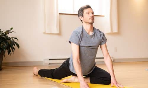 dominic from surya montreal performing a yoga posture